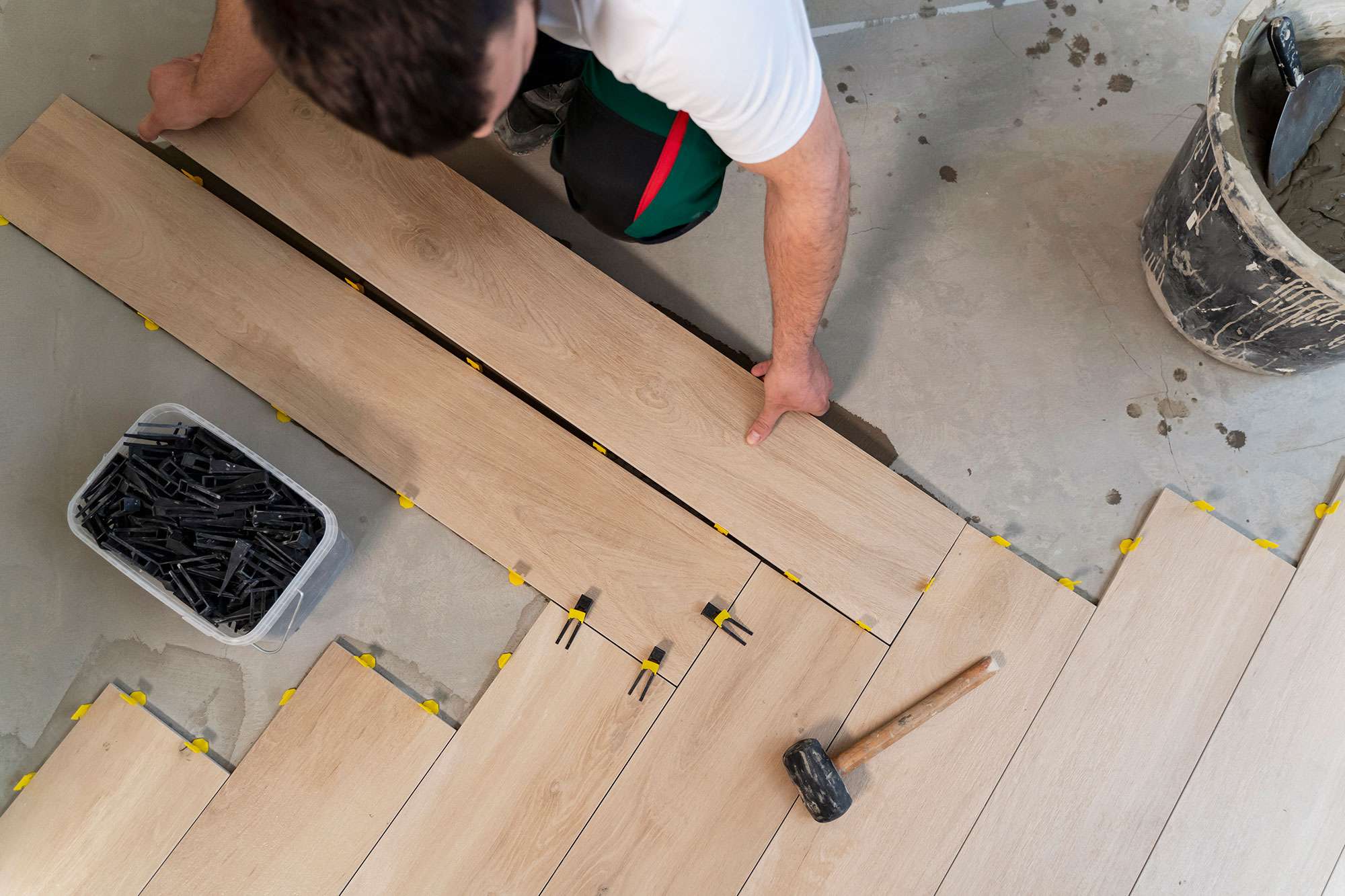 Top view man tiling floor