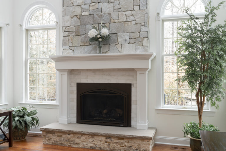 Haverford stone fireplace and hearth with white custom mantle and trim.