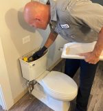 The Werrlein Companies repair person services a toilet.