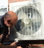 The Werrlein Companies repair person services an HVAC system located outside